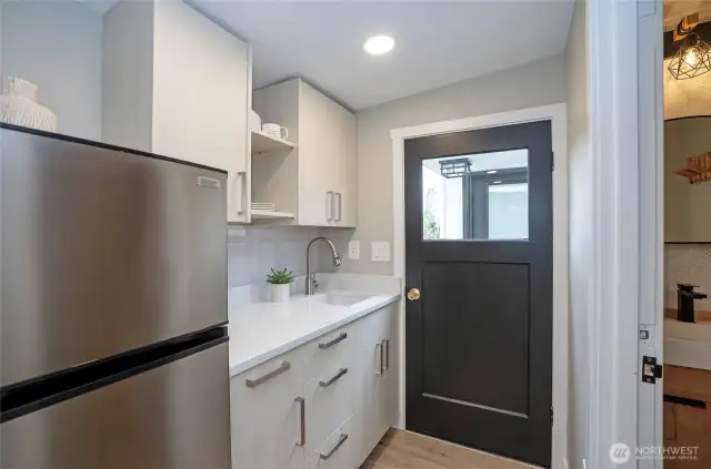 Attractive cabinets with a Quartz counter and new finishes make this an inviting hang out room.