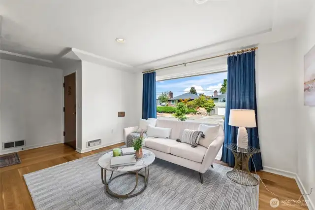 Step into the living space featuring beautifully refinished oak flooring and large windows.