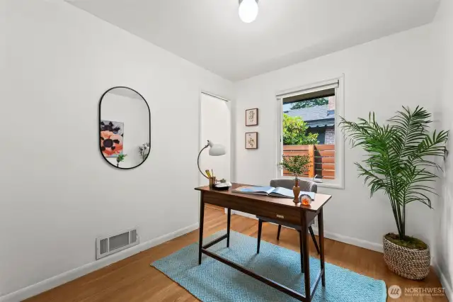The second bedroom features windows overlooking the side yard, and refinished hardwood floors.