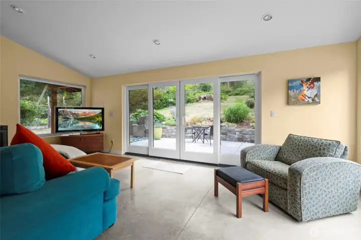 This space is very flexible. It has a wood fireplace for those chilly winter evenings, and large sliding doors to enhance indoor/outdoor living.
