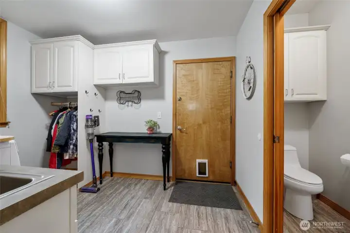 Laundry/mud room with built-in cabinetry and half bath.