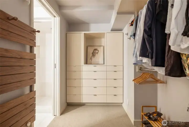 Primary walk-in closet with heated towel bar and built-ins.