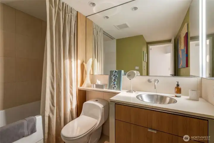 Full bath features walnut cabinets, heated floors, stainless medicine cabinet and sink, and marble stone for the counters, shower, and tub surround.