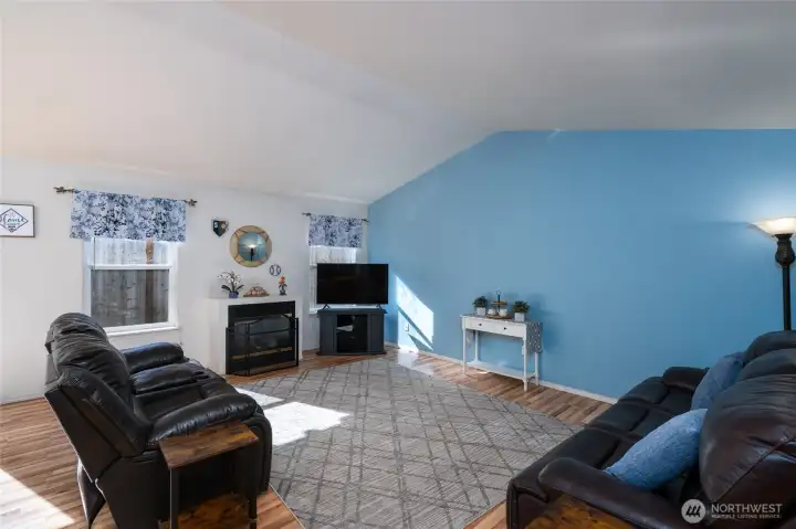 Living room is spacious with vaulted ceilings.