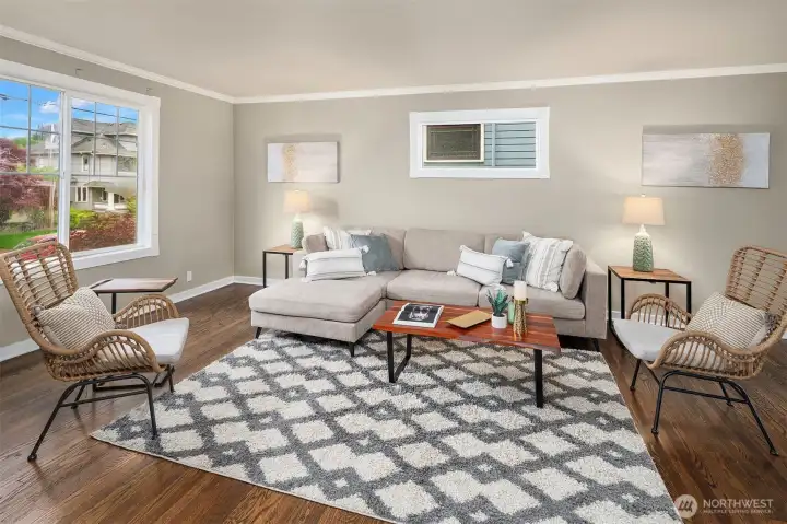 Spacious living room with hardwood floors and big windows for natural lighting.