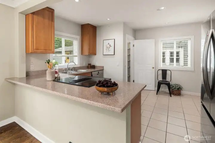 Kitchen has stainless steel appliances, slab stone countertops and walk-in pantry.