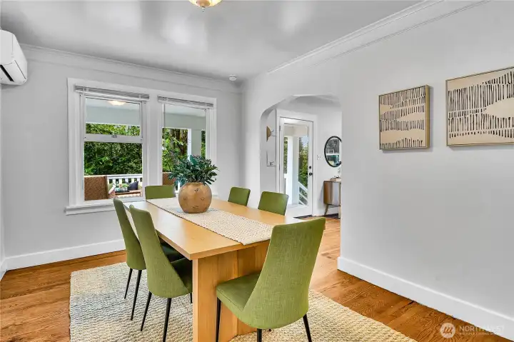 Gather with family and friends in the spacious dining room showcasing hardwood floors, charming coved archways, a built-in storage alcove, and year-round comfort with a mini-split heating and A/C system. Gather with family and friends in the spacious dining room showcasing hardwood floors, charming coved archways, a built-in storage alcove, and year-round comfort with a mini-split heating and A/C system.