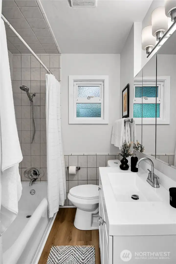 Full main level bathroom featuring new laminate flooring and generous linen storage to keep everything organized. Full main level bathroom featuring new laminate flooring and generous linen storage to keep everything organized.