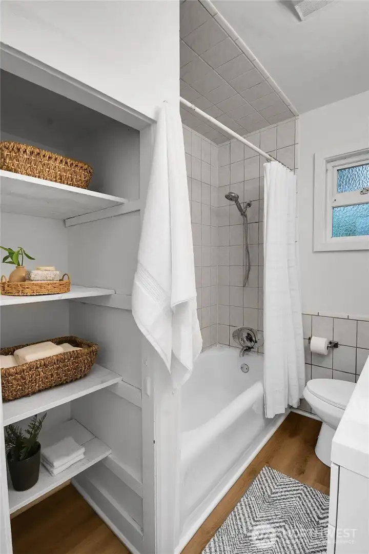 Full main level bathroom featuring new laminate flooring and generous linen storage to keep everything organized. Full main level bathroom featuring new laminate flooring and generous linen storage to keep everything organized.
