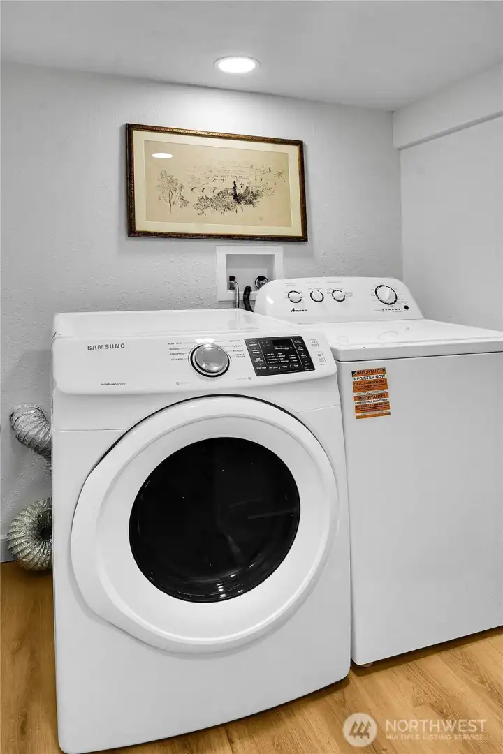Dedicated laundry room with new laminate flooring and extra space for shelving, storage, or a hanging station. Dedicated laundry room with new laminate flooring and extra space for shelving, storage, or a hanging station.