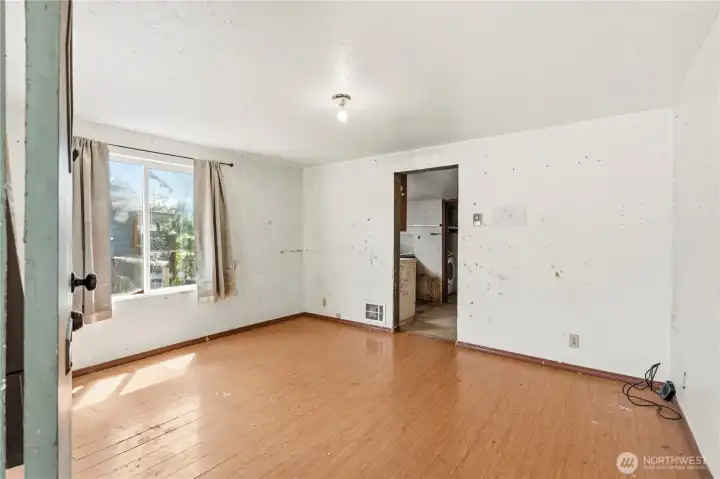 Enter to the living room with laminate hardwood flooring and some updated vinyl windows.