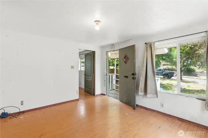 Another view of the living room looking out to the front entrance and windows overlooking the front yard.