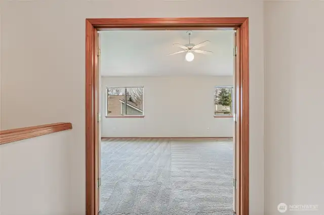 At the top of the stairs and to the left the French doors leading into the spacious primary bedroom.