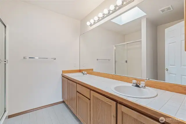 Primary bath, double sinks, toilet and shower.