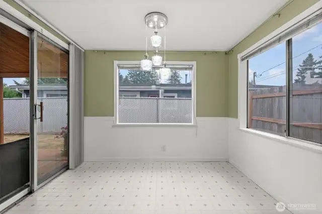 The breakfast nook/Dining space opens to the covered back porch, and is well lit by large windows.