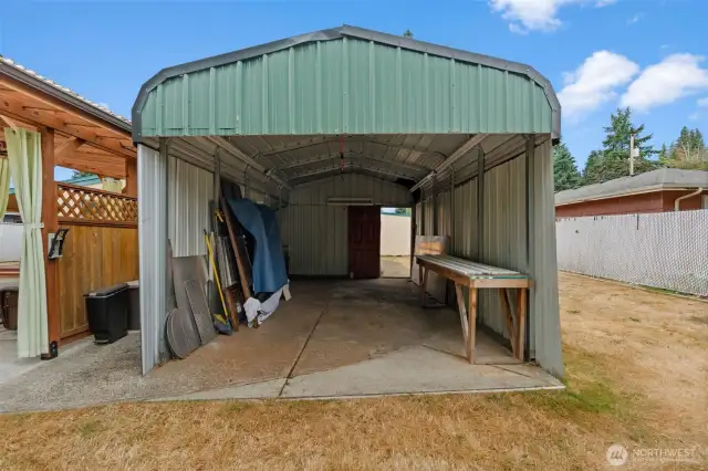 Large covered carport/shed for workshop and storage.