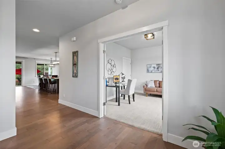 Elegant glass French doors open to a versatile space; ideal for office or fourth bedroom.