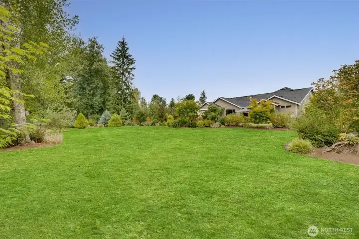 Lush lawn and professional landscaping enhance the beauty of this immaculate, park-like 1+ acre oasis