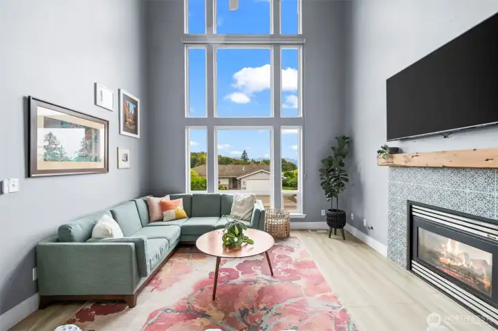 Light-filled living room with a wall of windows and Olympic Mountain views.