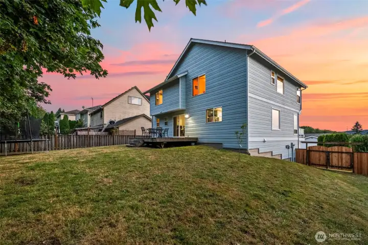 Slight slope in fenced-in backyard. Low-maintenance landscaping ideal for busy lifestyles. Lots of room to play.