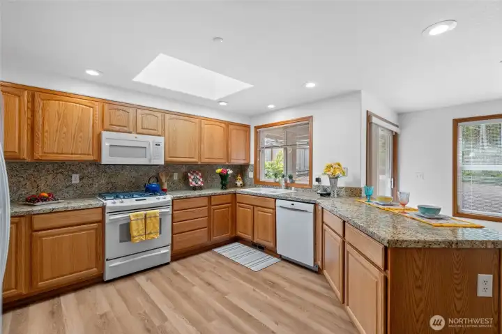 Spacious kitchen with beautiful LVP flooring, granite counter tops and a dual fuel stove.