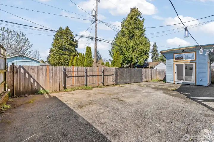 Alley access leads to gated backyard there is a large paved area for parking or patio use