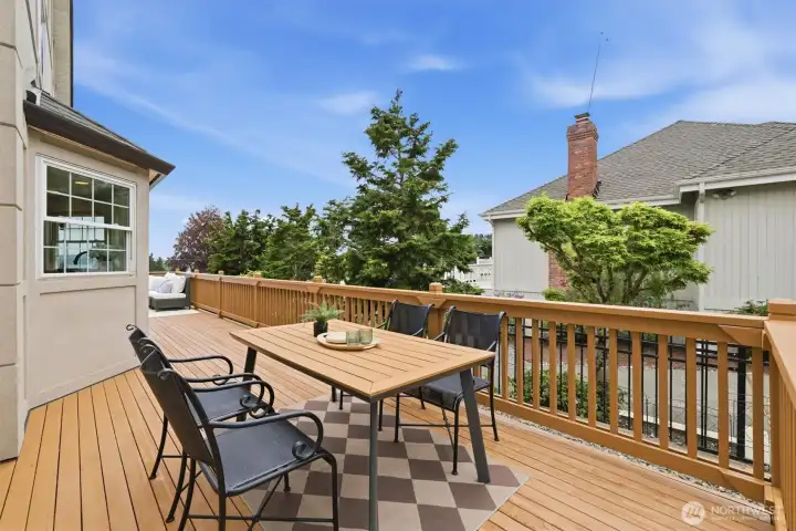The deck has a fresh coat of paint and offers ample seating for outdoor dining and relaxing. To the right is a turf area for your four-legged friend.