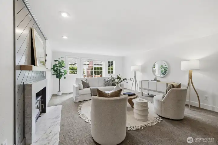 This main level family room is versatile as media or work-from home. The wood fireplace is on the left. A slider opens to the deck.