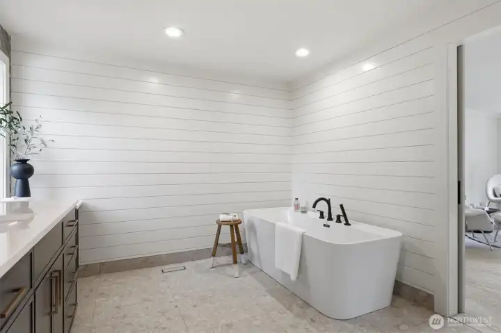 The primary bathroom includes a stunning soaking tub with wand, heated flooring and shiplap walls.