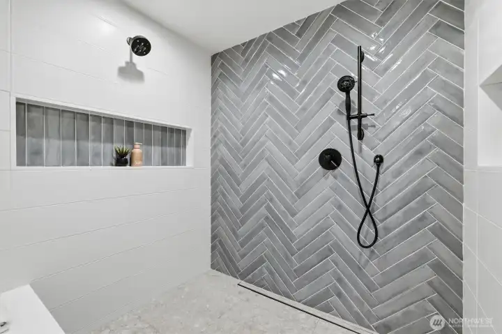 The primary shower is spa-like and beautifully designed. Notice the double shower head.