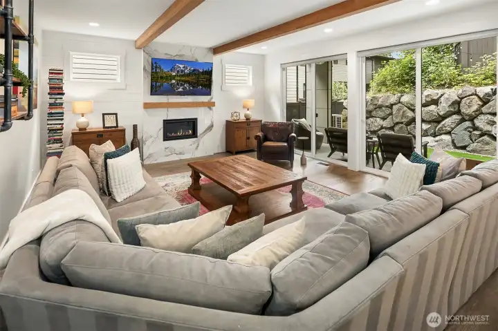Vaulted family room with exposed beams and forested outlook