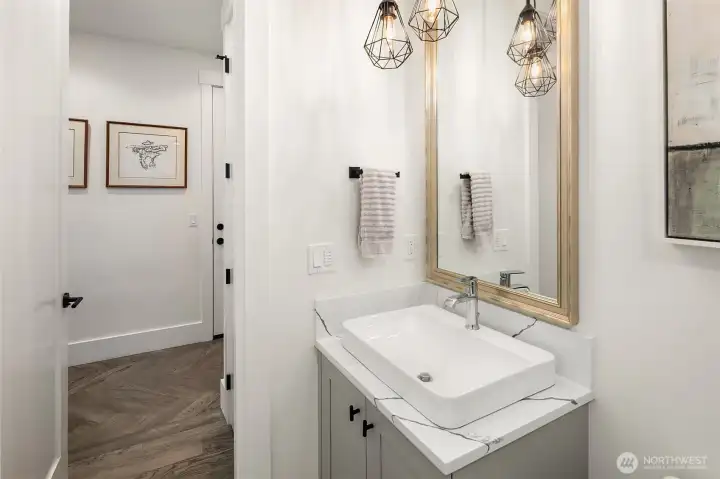 Powder room finished in white tile and matte black hardware