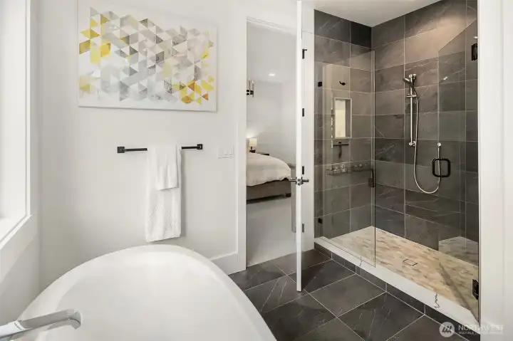 Glass-enclosed walk-in shower with feature tile wall