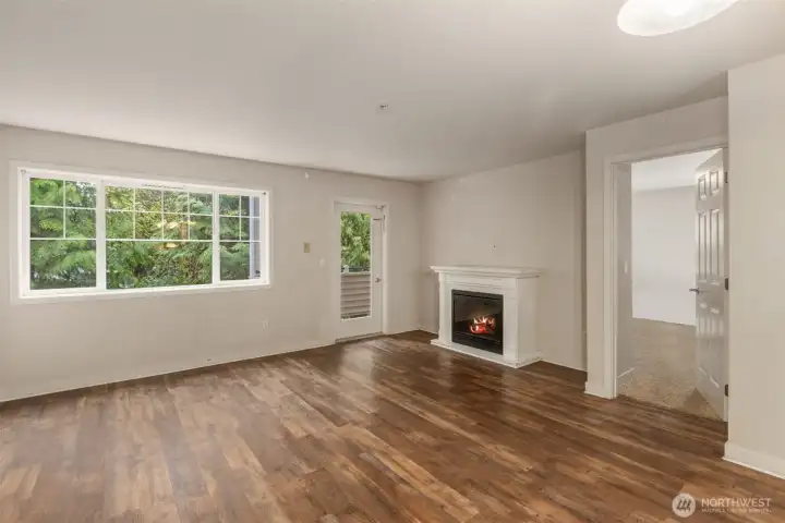 Open living room with balcony access and electric fireplace