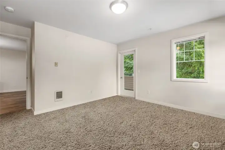 Spacious primary bedroom with double closet for practical storage and private door to balcony.