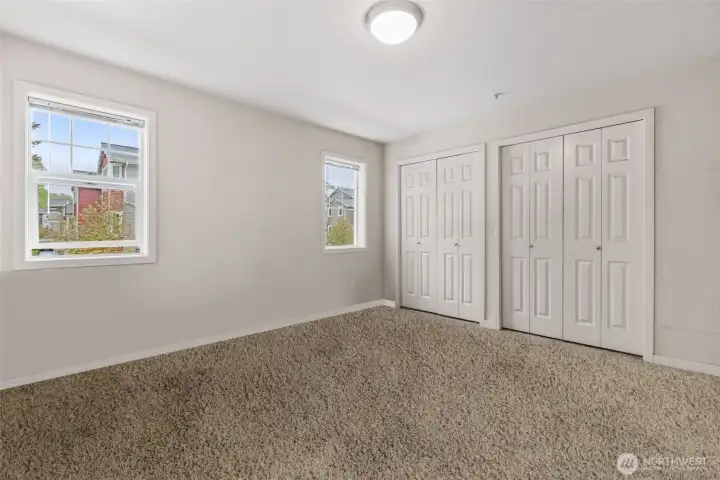 Spacious primary bedroom with double closet for practical storage and private door to balcony.