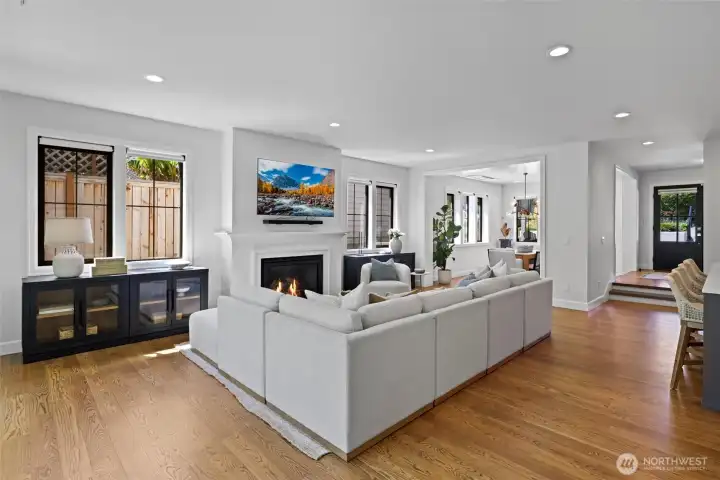 Main open-concept living space with seamless flow to Kitchen, Dining & Outdoor entertaining patio through Fleetwood sliding doors. Gas Fireplace. TV conveys with home.