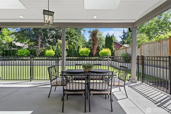 Backyard covered entertaining patio with skylights & curated light fixtures