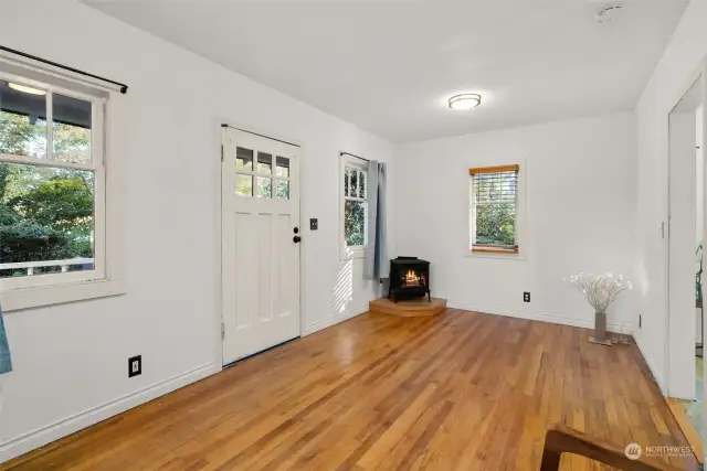 The living room features a gas stove and hardwood floors.