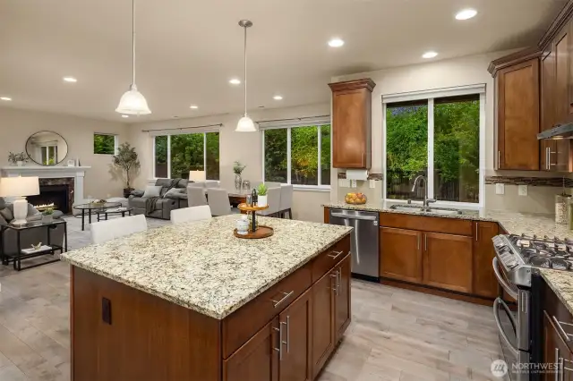 Spacious island with bar seating overlooks the dining and family rooms