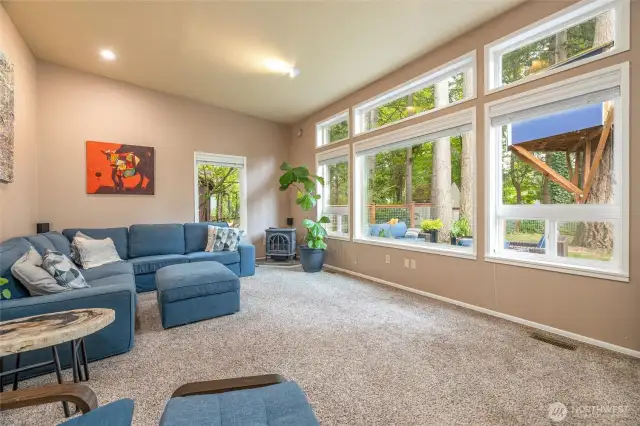 A massive family room with vaulted ceilings and huge windows sits adjacent to the kitchen dining area.