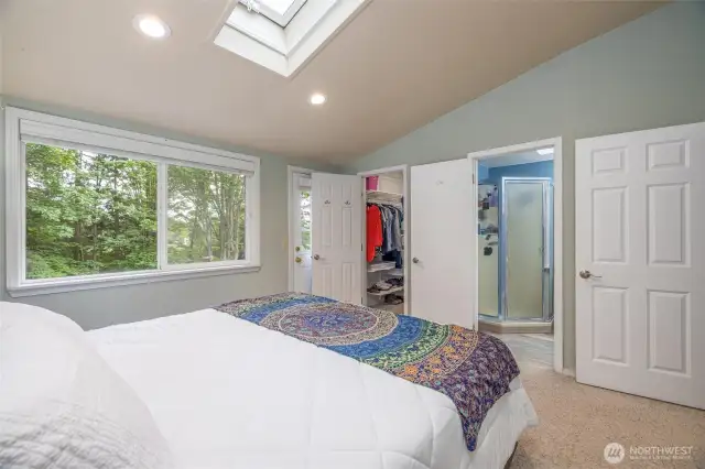 A view to the walk in closet in the primary bedroom, plus the attached "jack and jill" bathroom.
