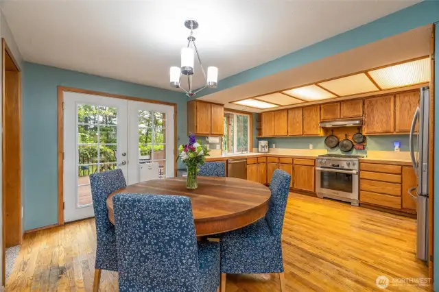 A large dining area is adjacent to the open kitchen, with french doors to the large back deck.
