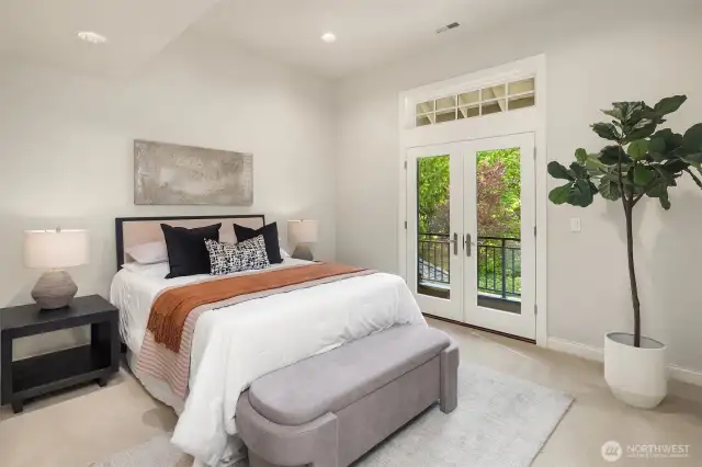 This bedroom up (facing front of the home) features vaulted ceiling and balcony.