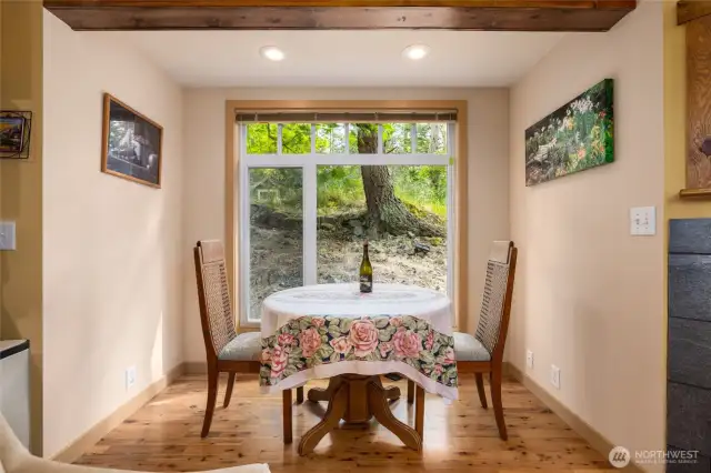 Huge picture window of the natural hillside makes the perfect backdrop to the dining room