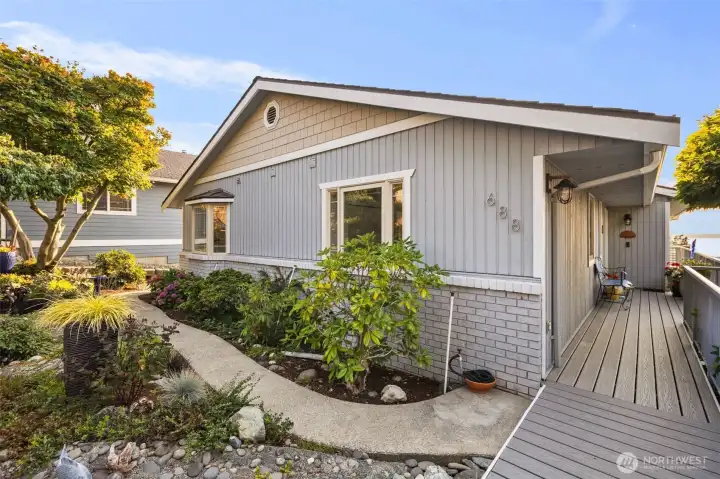Lovely landscaping in the front yard and composite/Trex decking leads to the front door.