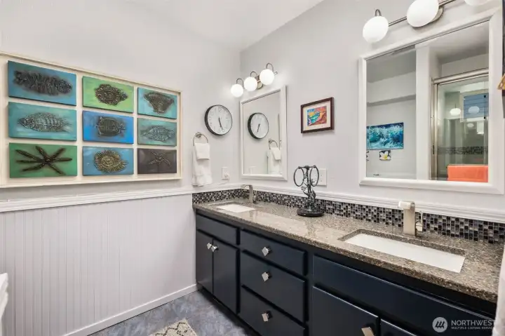 Primary bathroom with skylight, dual sinks and walk-in shower.