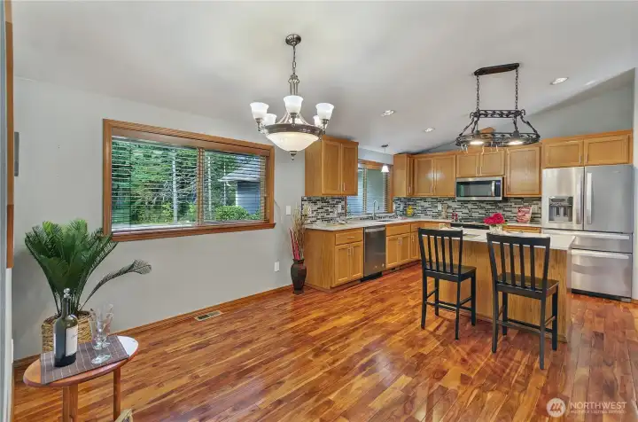 The kitchen extends seamlessly into a refined dining space - an open dining area comfortably fits a full-size table