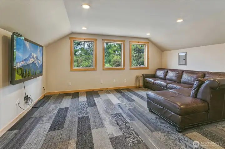 bright lounge area framed by three large windows, flooding the space with natural light