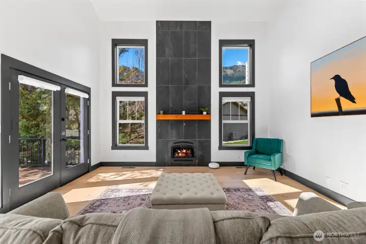 Fireplace focal point with surrounding windows bringing in natural light and outdoor views